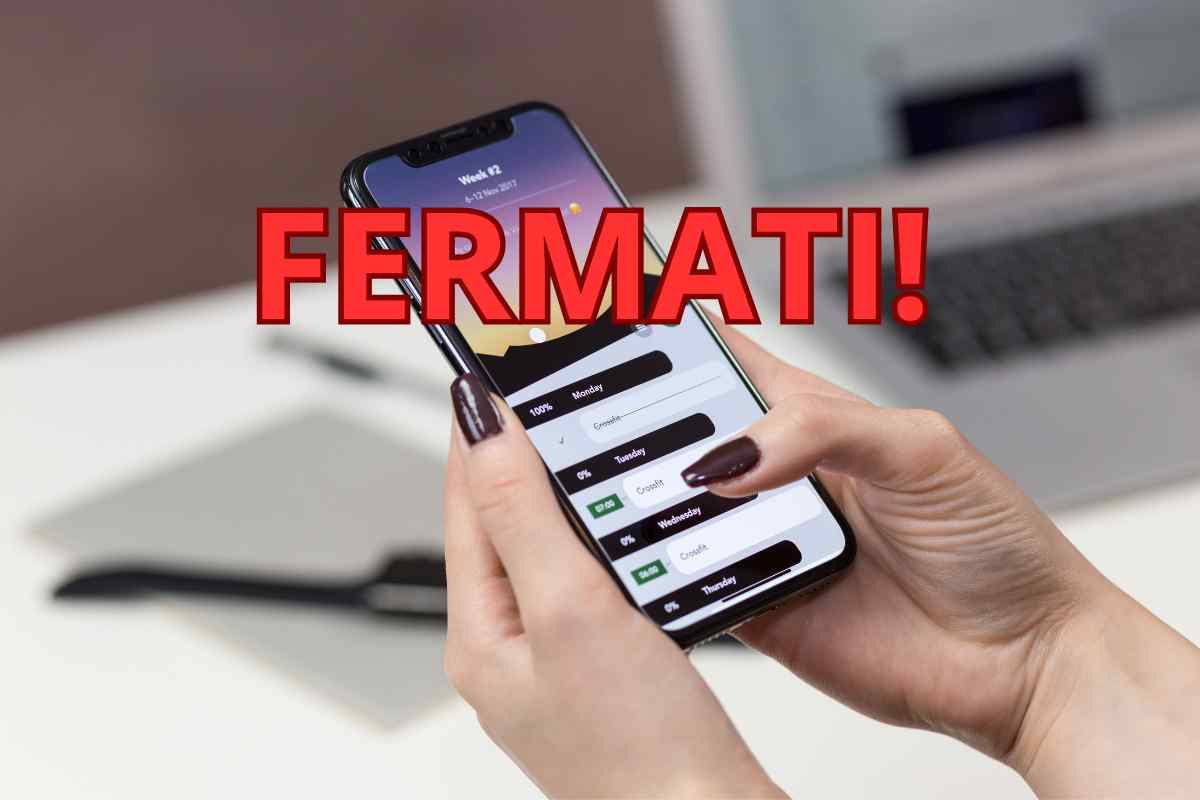 mani che usano smartphone e scritta fermati