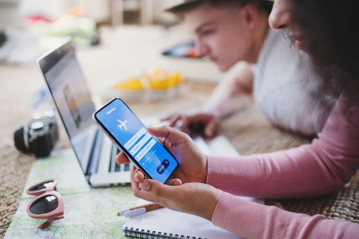 Coppia: lei al cellulare prenota volo, lui al PC