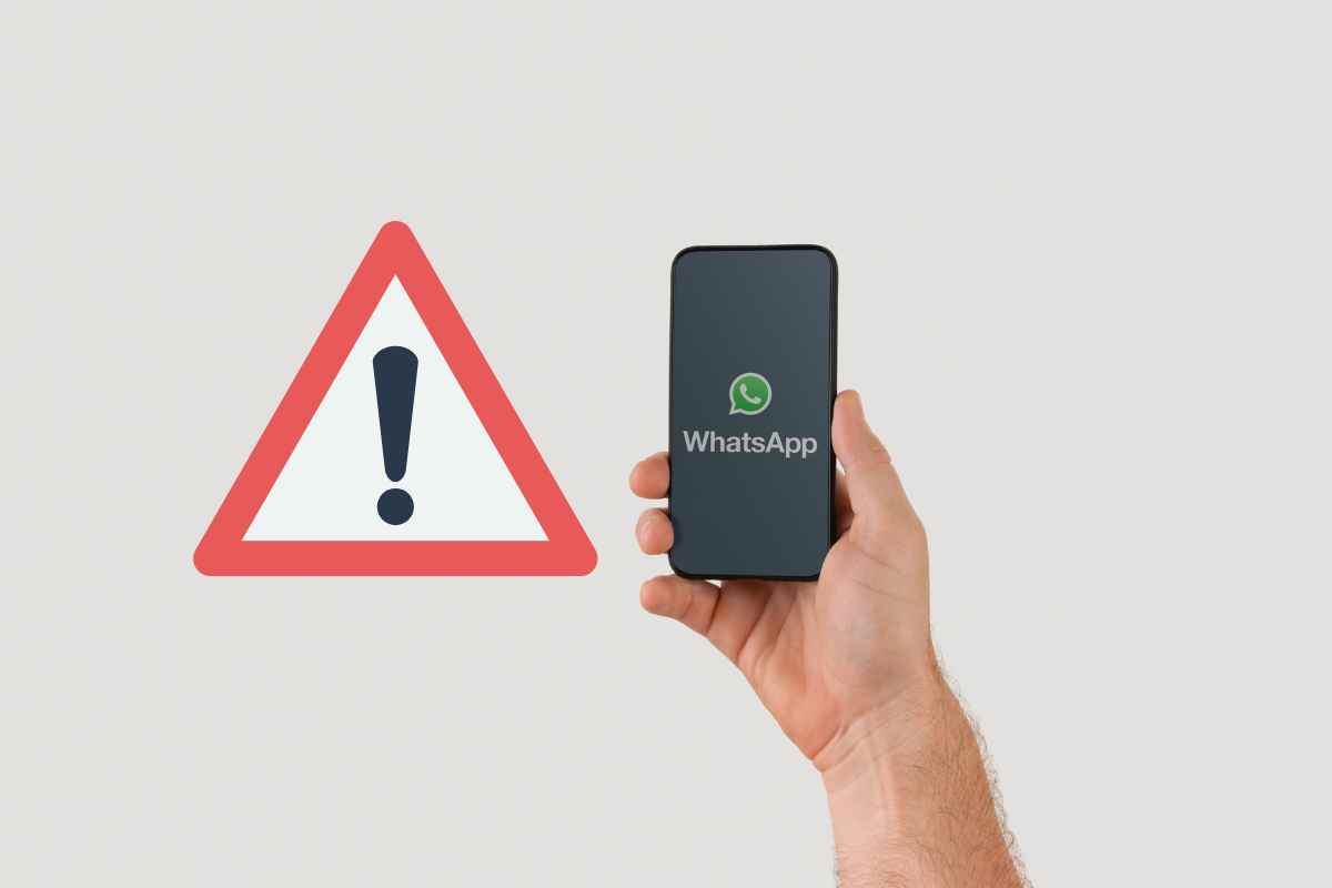 man oche tiene un telefono in mano con il logo di whatsapp e il triangolo del pericolo