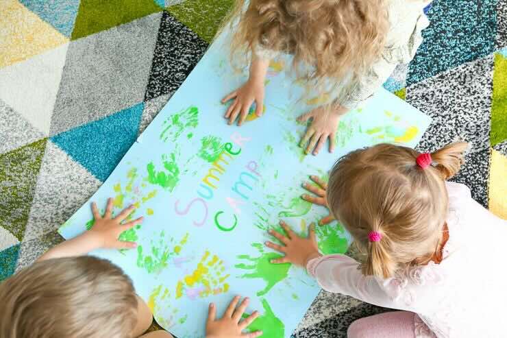 Bambini con mani su cartellone colorato
