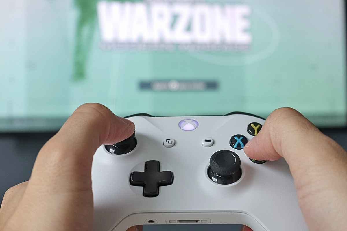 mani che giocano a cod warzone su una console xbox