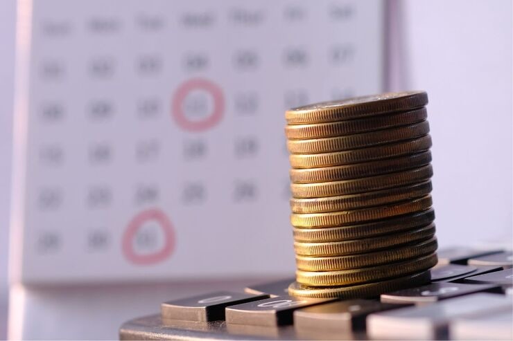 Calcolatrice, monete, calendario con date cerchiate