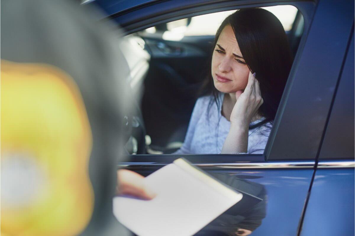 Ragazza guarda fuori dal finestrino agente con documento in mano