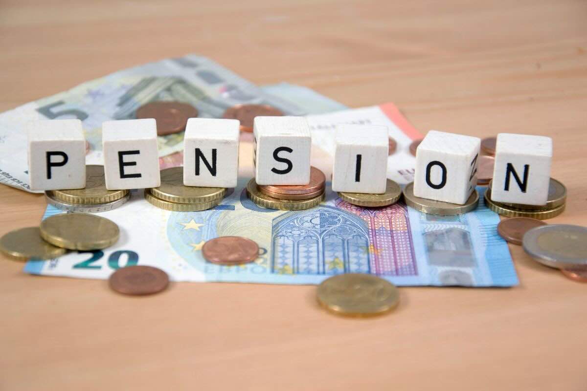 Dati con scritto "Pension", banconote e spiccioli euro