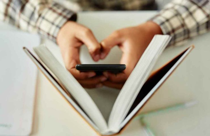 ragazzo che usa lo smartphone di nascosto in classe
