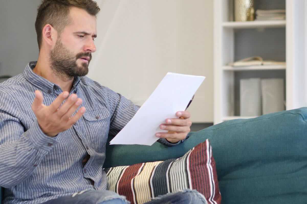 Uomo legge stizzito documento