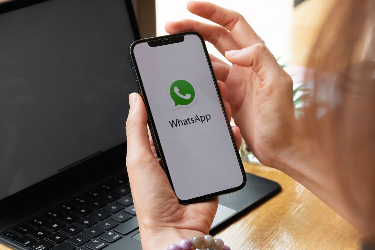 Mani tengono cellulare con schermata Whatsapp