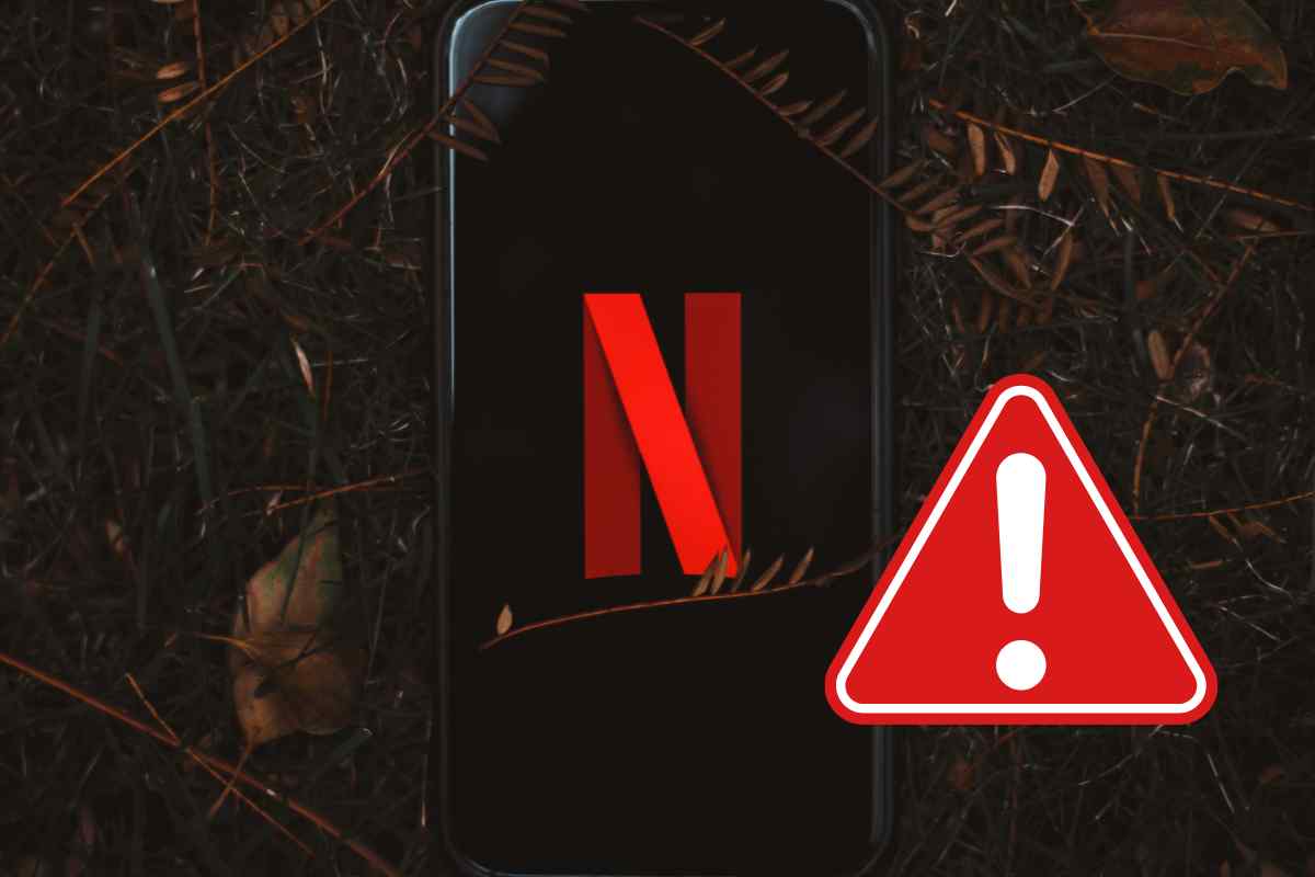 cellulare con logo Netfliz e triangolo di pericolo
