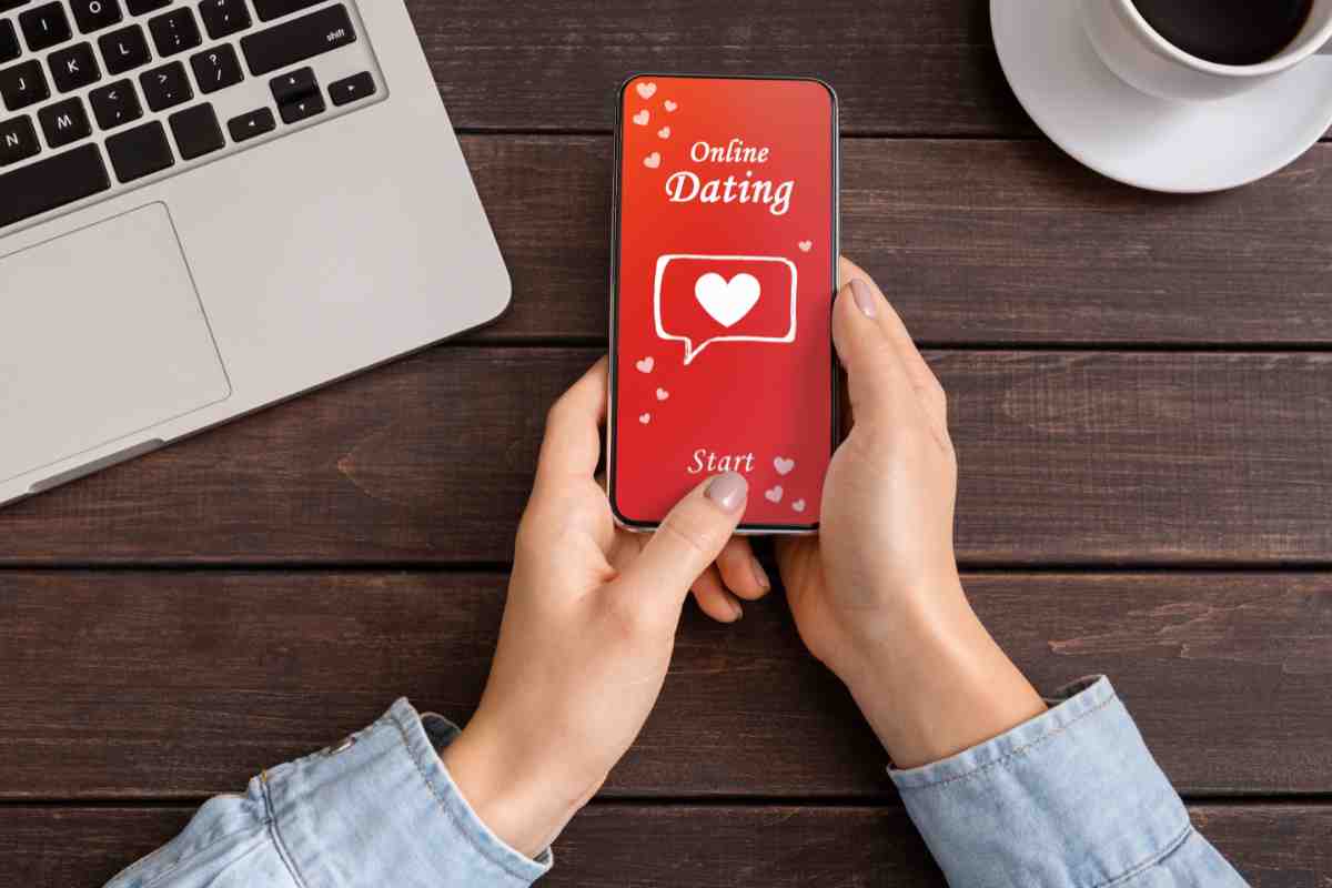 cuore e scritta dating su schermo di smartphone tenuto in mano da una ragazza