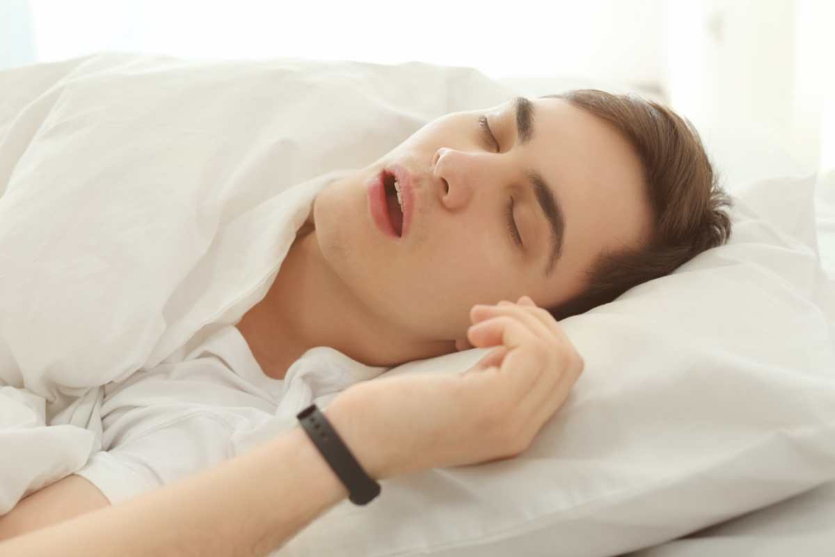 ragazzo dorme con bocca aperta e al polso ha un Apple Watch per controllare le apnee notturne