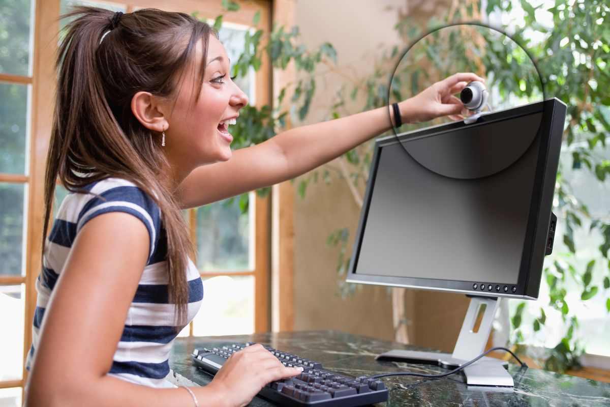 Ragazza sistema la webcam sul computer