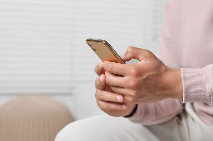 Mani tengono smartphone e digitano sullo schermo 