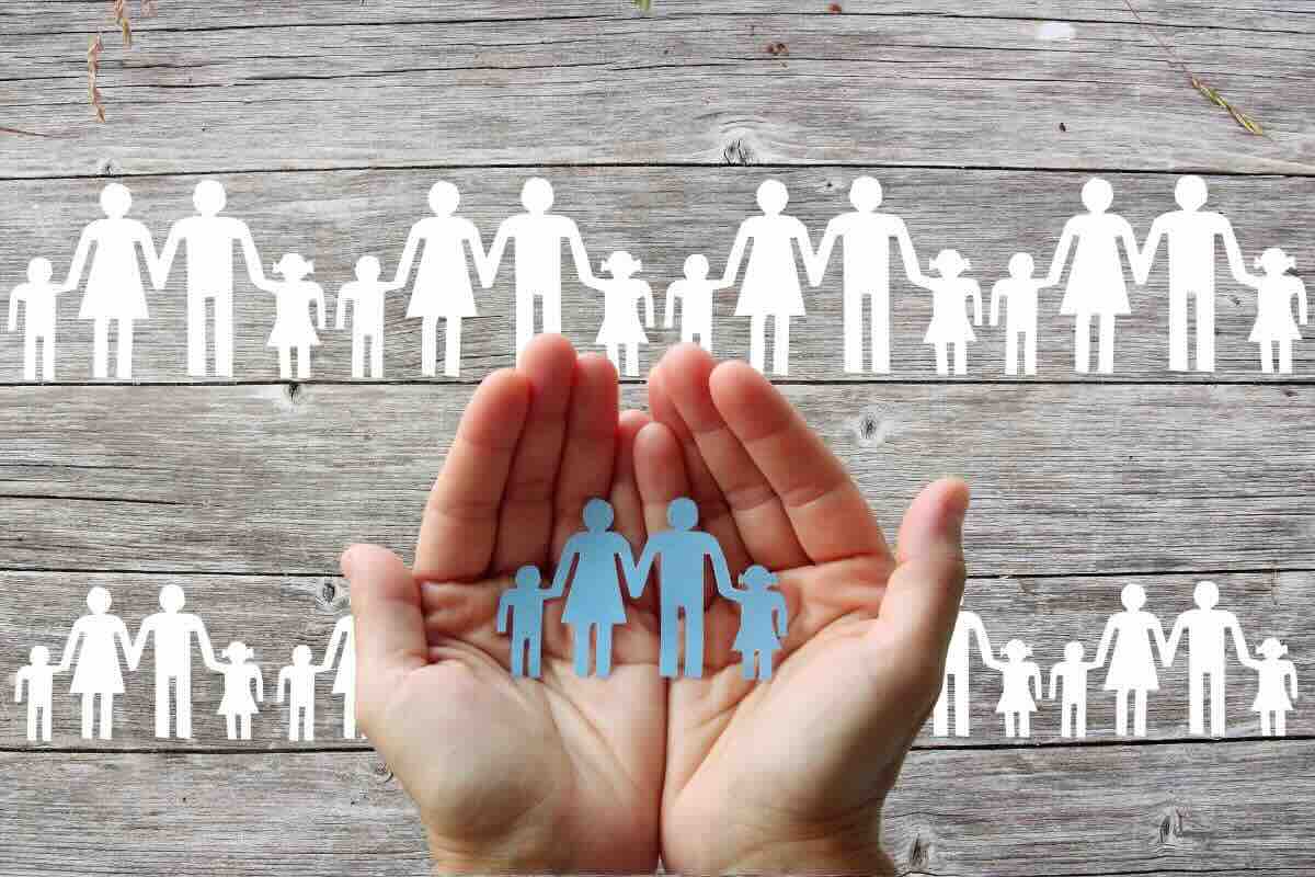 Omini carta su sfondo e famiglia 4 componenti omini di carta fra le mani