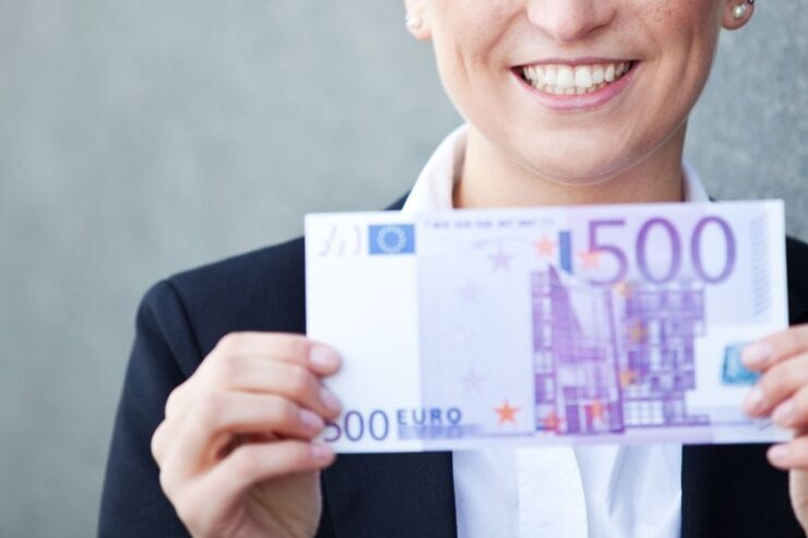 Donna sorridente con banconota da 500 euro in mano