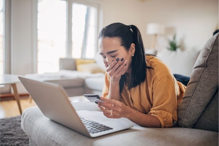 Donna disperata con carta davanti al PC
