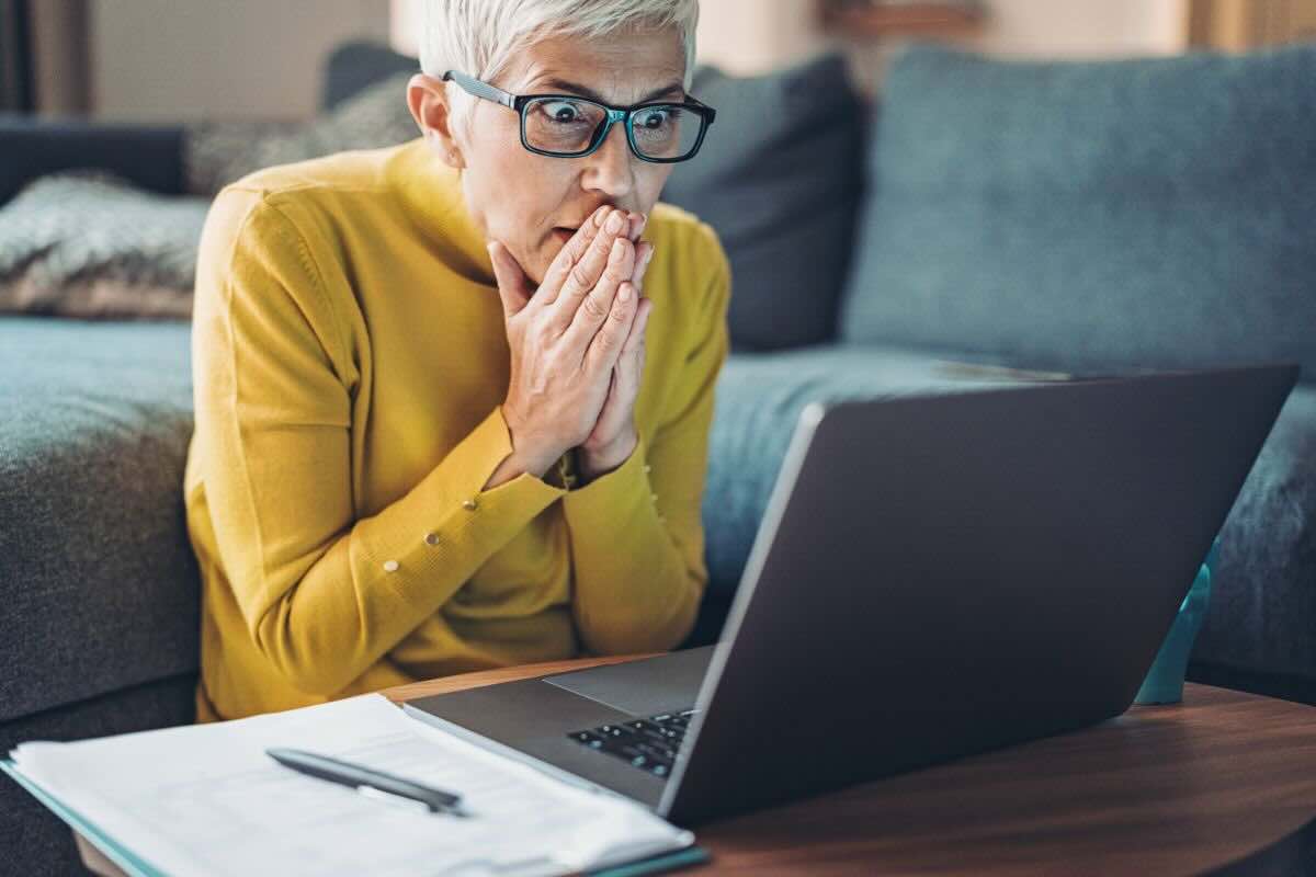 Donna guarda PC stupita e spaventata
