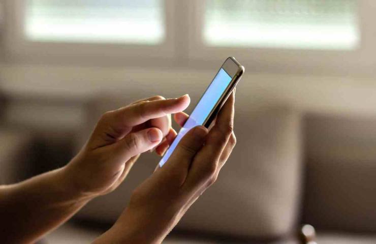 mani che usano un telefono