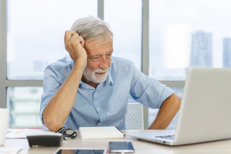 Uomo anziano guarda qualcosa sul computer