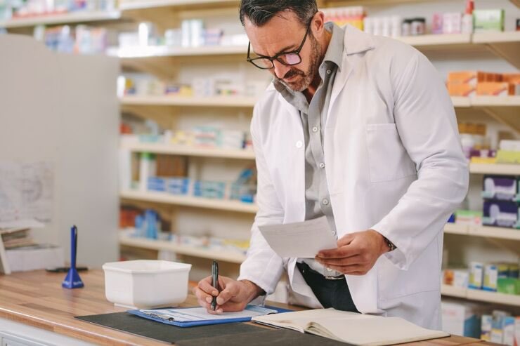 Farmacista scrive e tiene foglio in mano