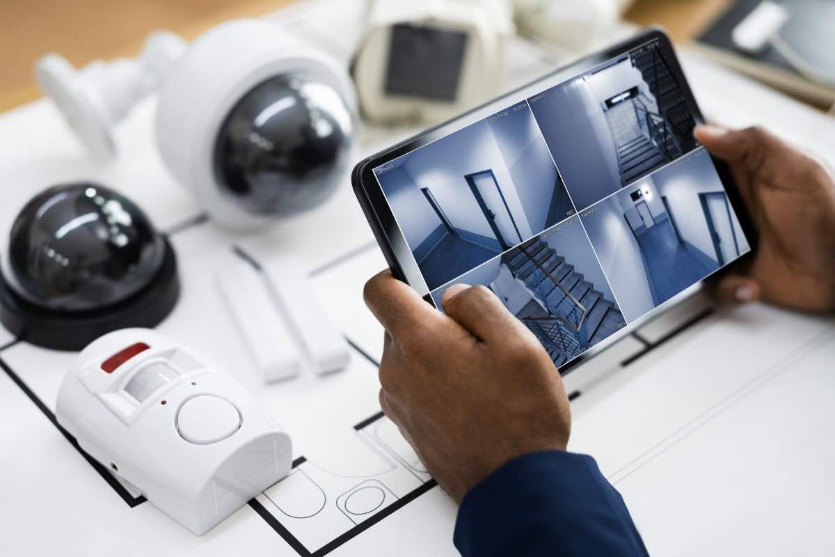 Uomo guarda su tablet ripresa telecamera casa
