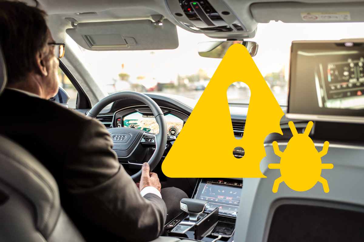 uomo in auto e simbolo di pericolo informatico
