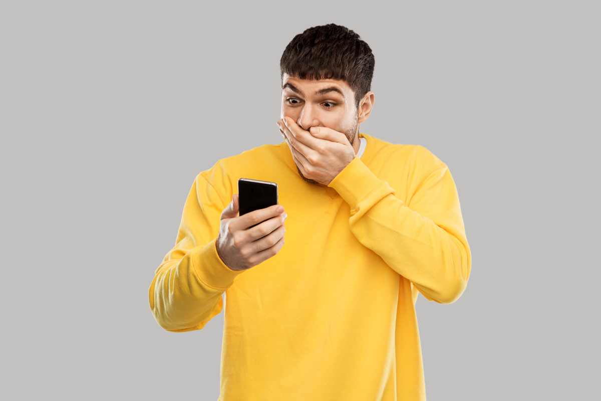 uomo sorpreso con telefono in mano