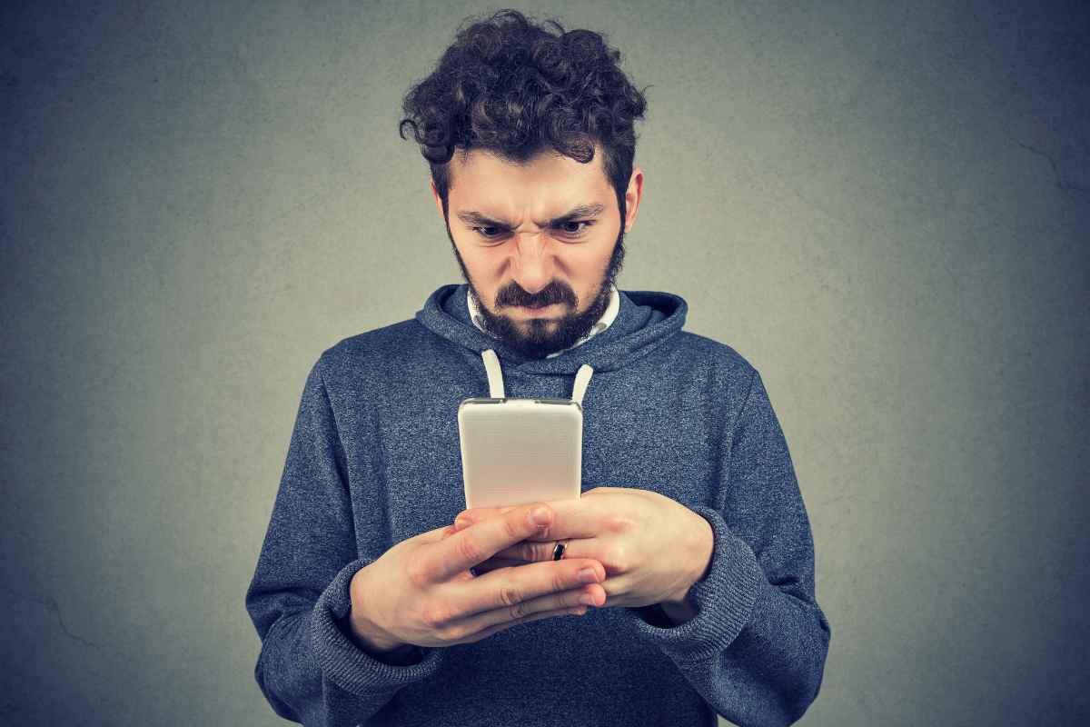 uomo con in mano lo smartphone che non funziona