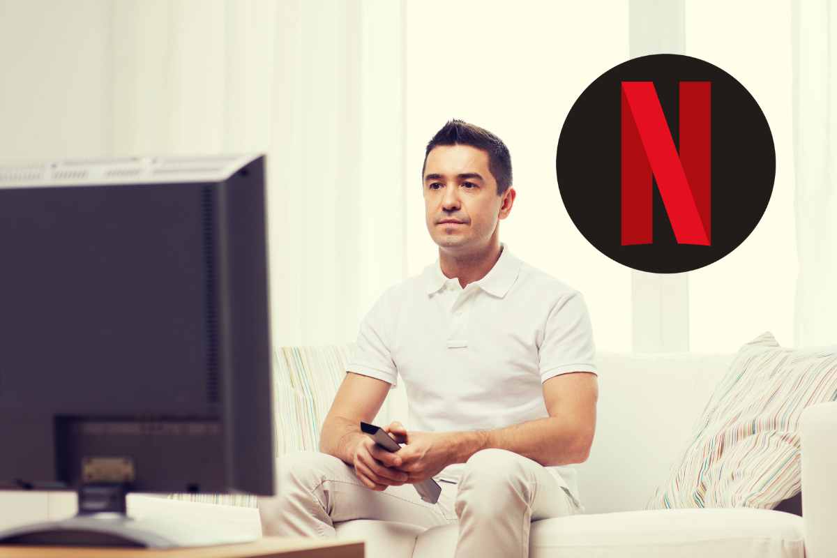 uomo sconsolato che guarda la tv con logo netflix