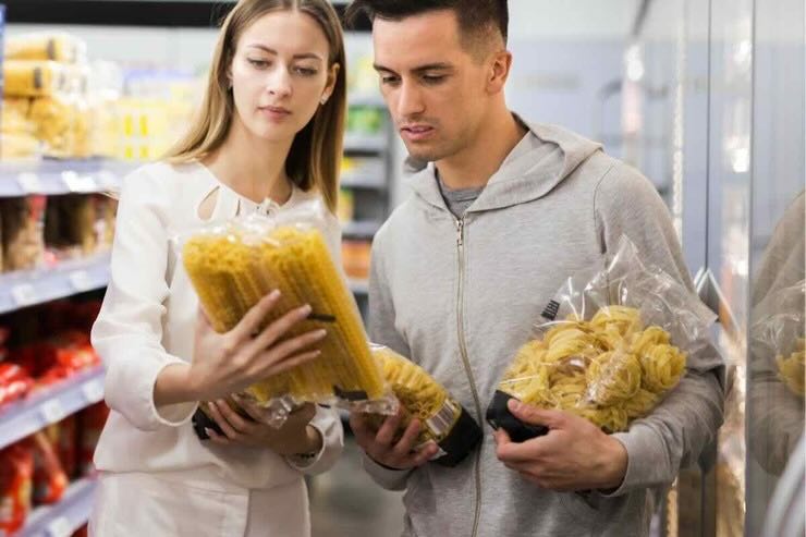 Coppia legge etichette su confezioni di pasta