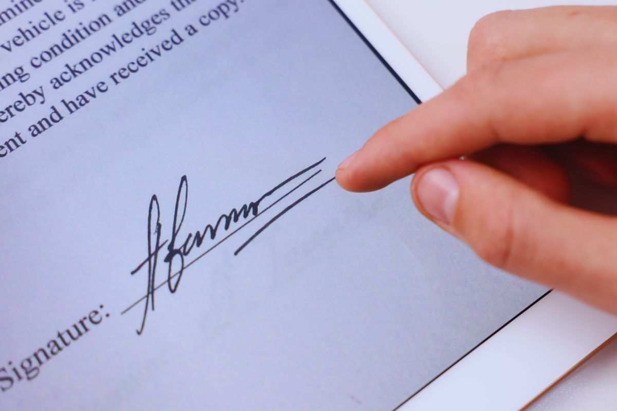 Donna che firma documento su tablet