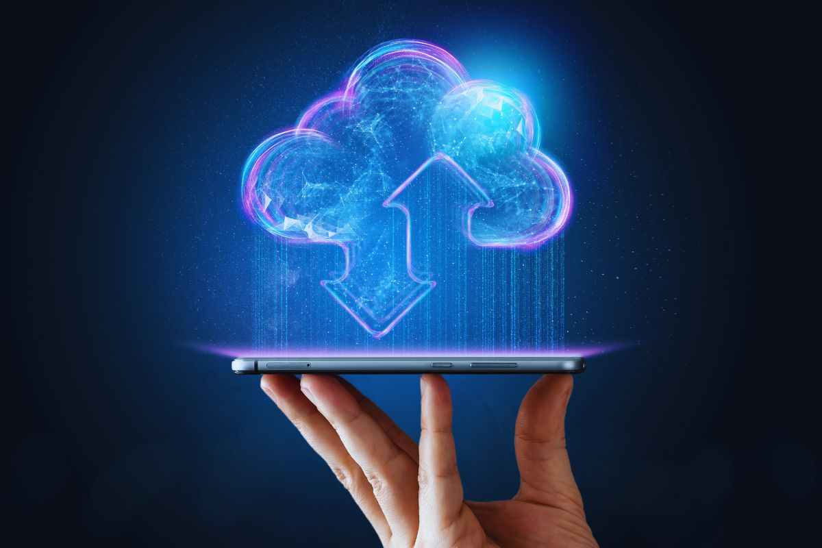 Persona che tiene smartphone e disegno rappresentante il cloud