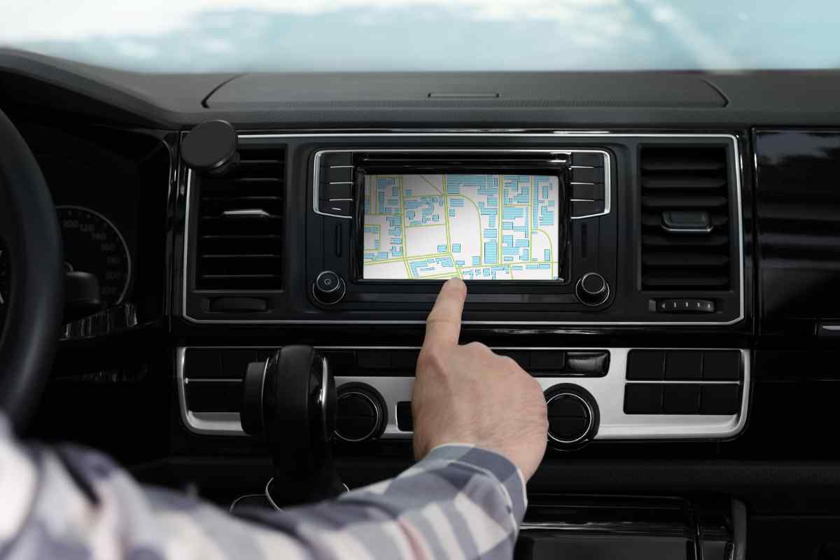 mano di un conducente sulla mappa del display in auto