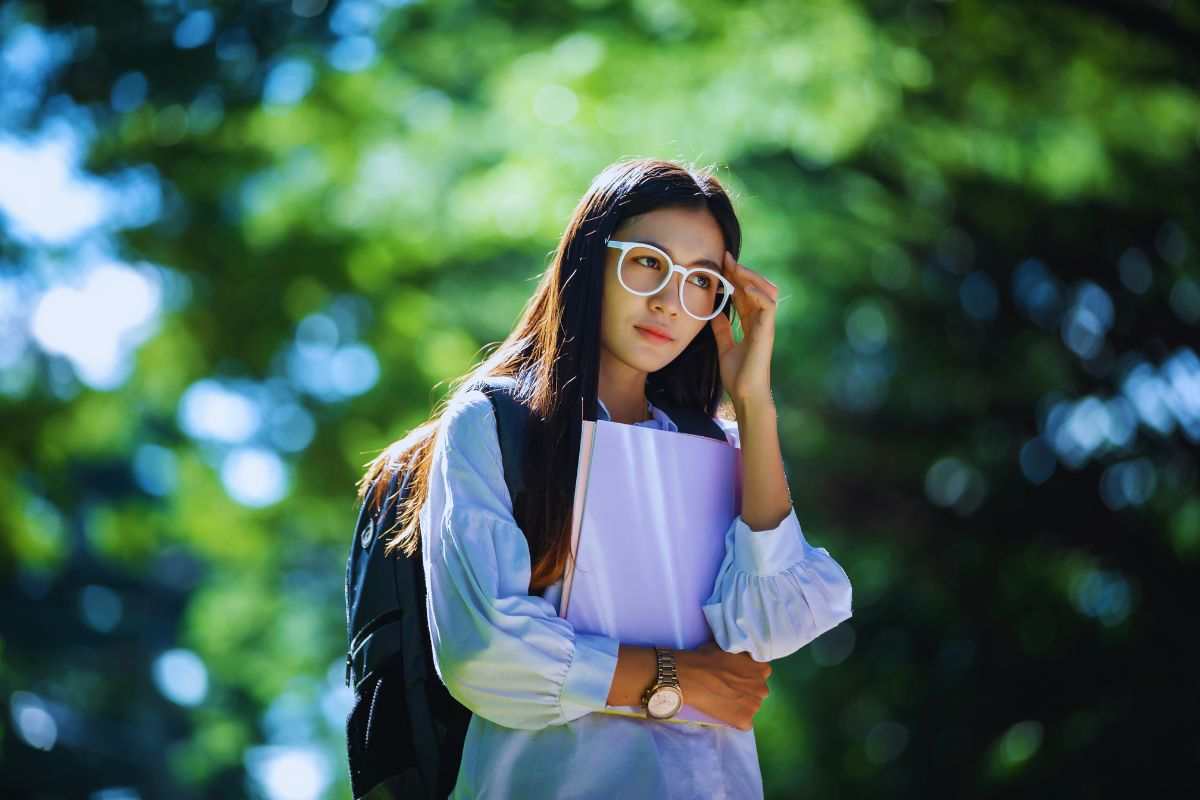 Ragazza con occhiali che cammina in un parco