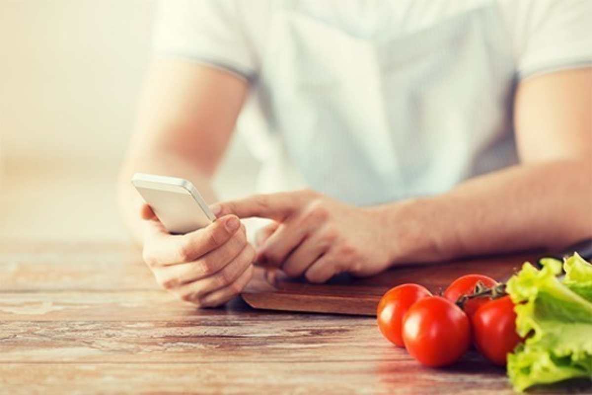 Persona che usa uno Smartphone in cucina