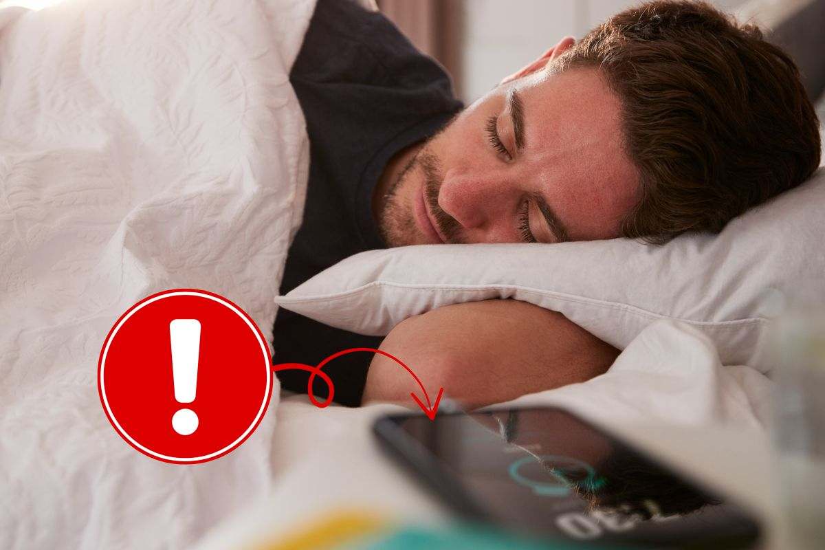 Ragazzo dorme con il telefonino sul comodino