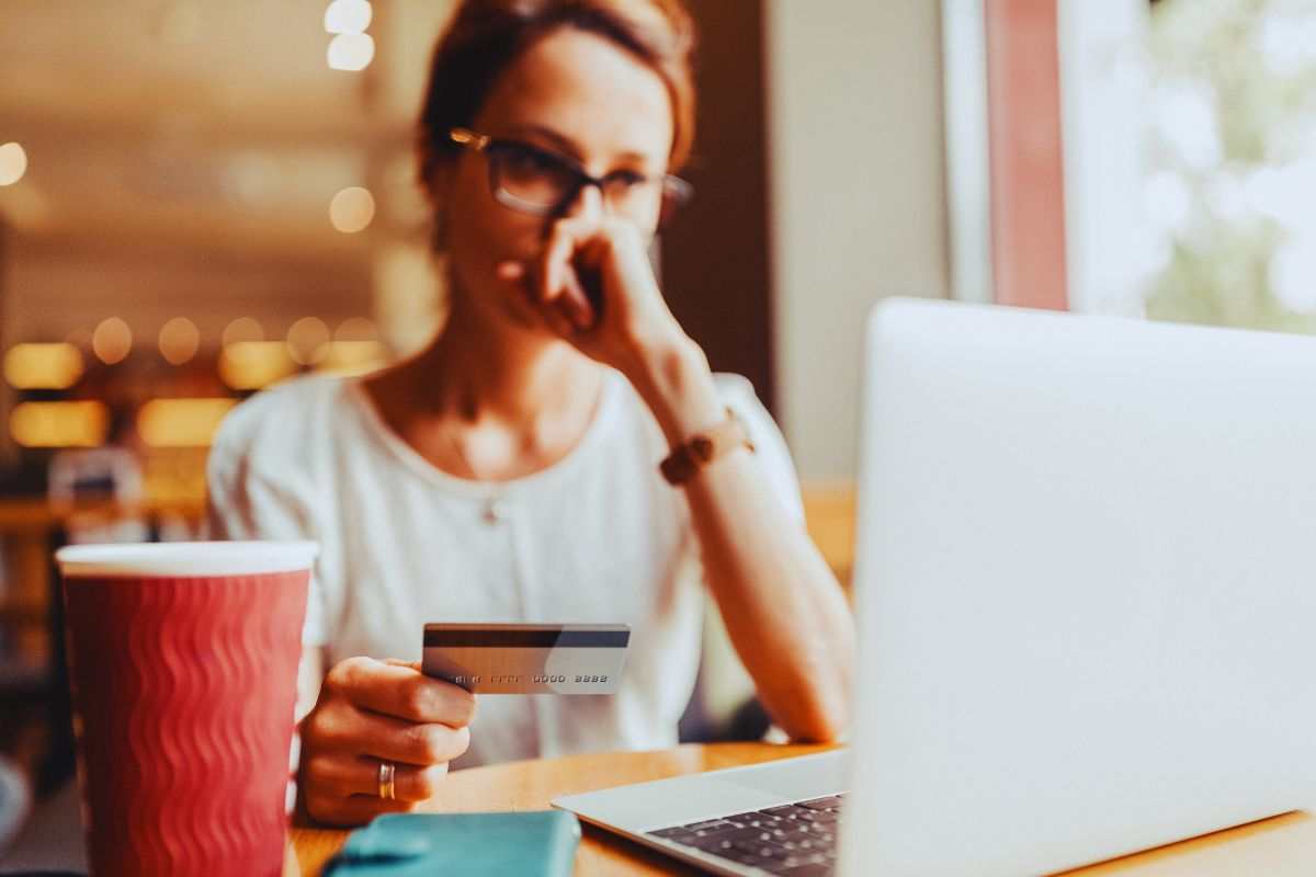 Donna preoccupata che tiene in mano la carta di credito