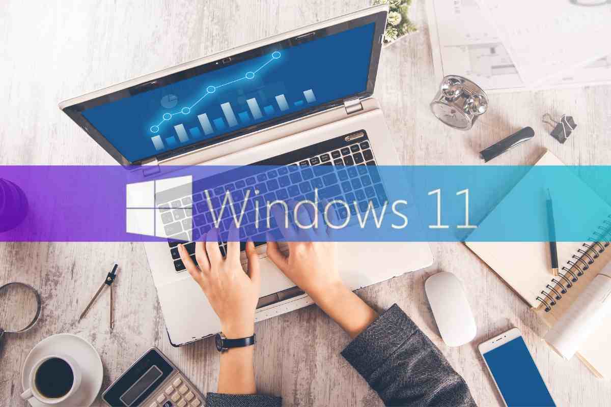 Un pc portatile in funzione ed il logo di Windows 11