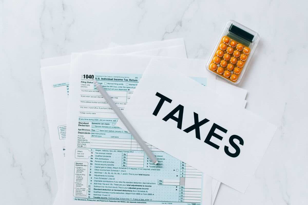 Documenti, foglio con scritto "Taxes", penna, calcolatrice