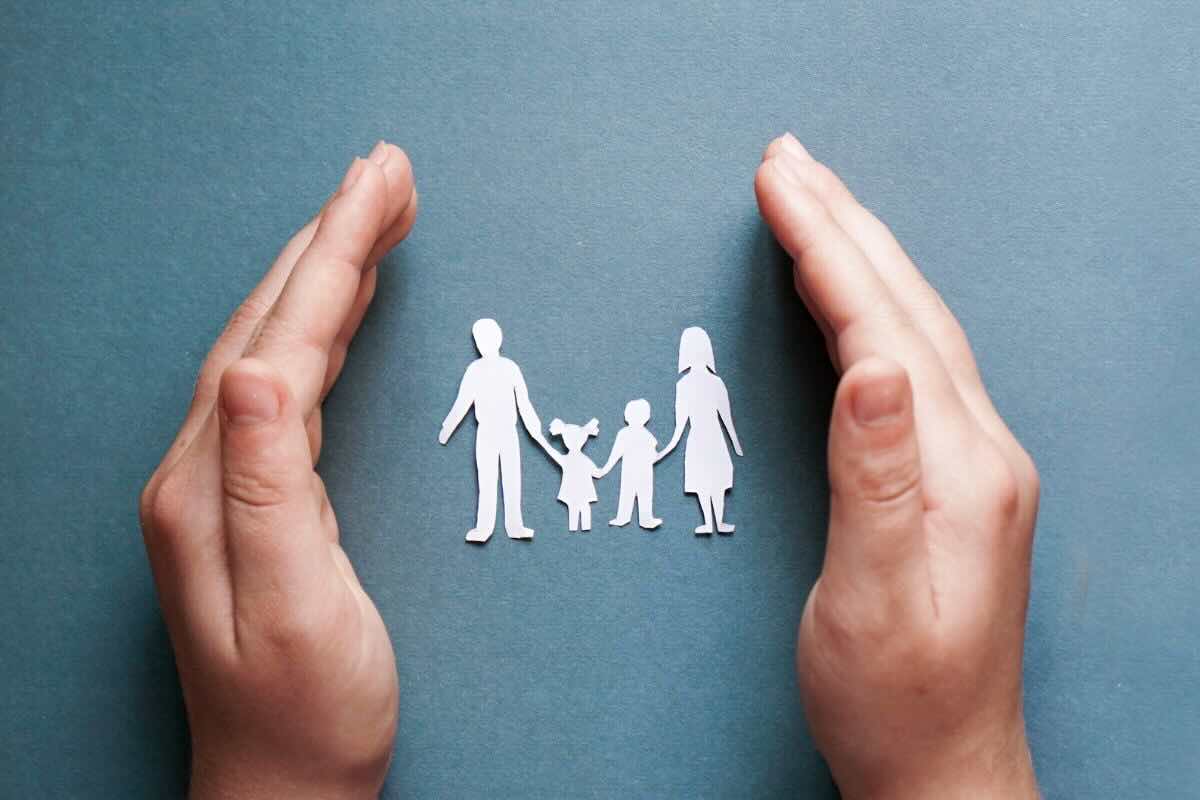 Famiglia composta da mamma, papà e due bambini, fra i palmi delle mani
