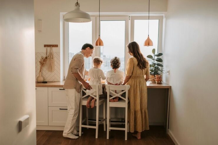 Famiglia composta da mamma, papà e due bambini alla finestra