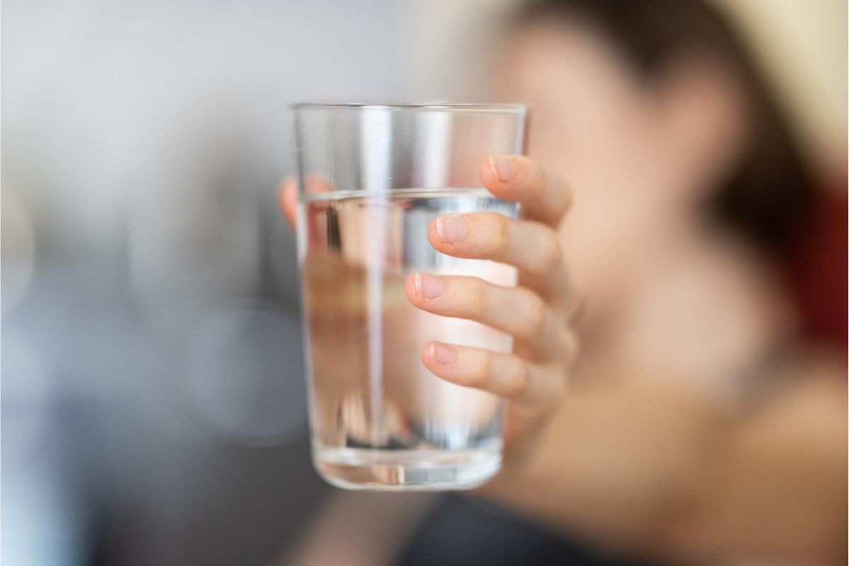 Mano con bicchiere d'acqua