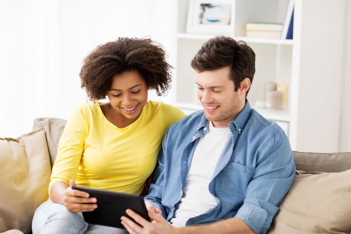 Donna e uomo felici con tablet