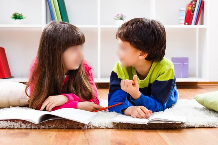 Due bambini parlano con quaderni davanti