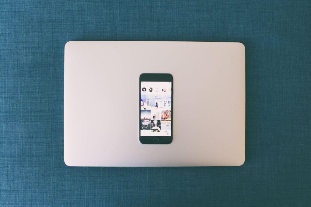 Instagram su smartphone poggiato su un laptop