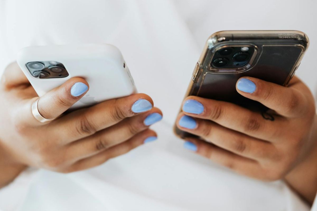Due smartphone in mano a una donna