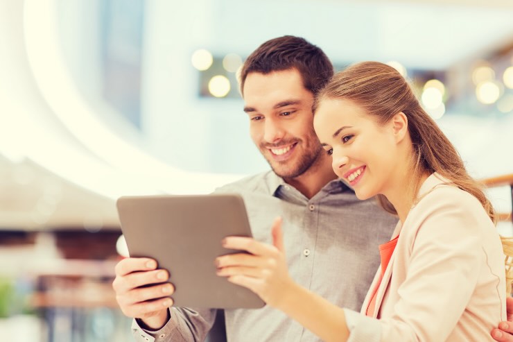 Uomo e donna felici con tablet