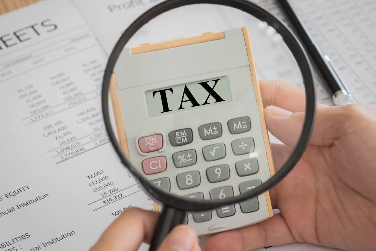 Documenti, lente di ingrandimento inquadra calcolatrice con scritto "Tax"