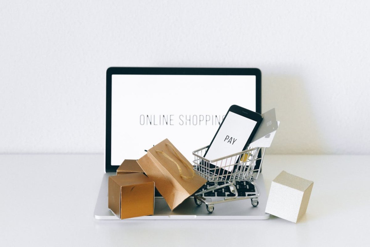 Laptop e smartphone con sacchetti degli acquisti