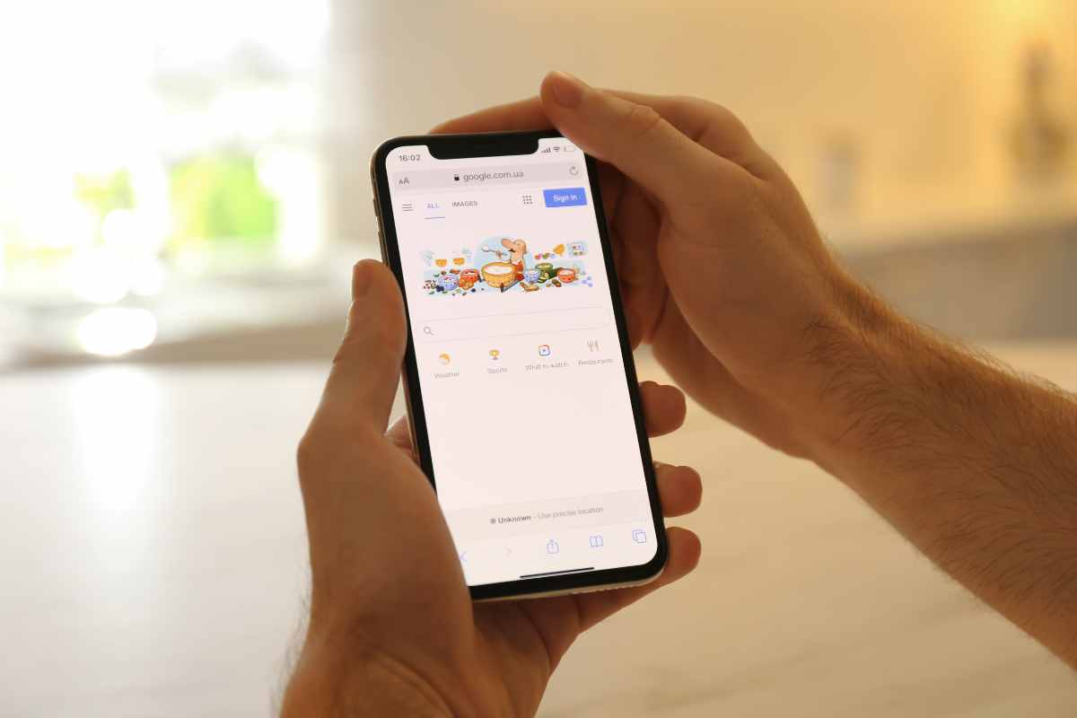 mani che usano uno smartphone con google