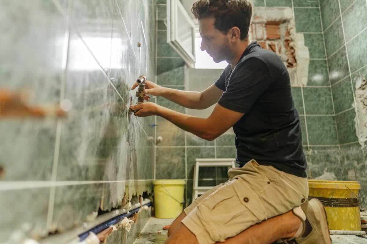 Uomo tocca mattonelle bagno
